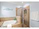 Bathroom featuring tiled shower, soaking tub and neutral color palette at 12675 Richezza Dr, Venice, FL 34293