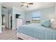 Light-filled bedroom features a ceiling fan, light-blue walls and luxury vinyl plank flooring at 12675 Richezza Dr, Venice, FL 34293