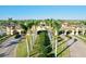 View of a beautiful community entrance with palm trees lining the manicured street and lush green spaces at 12675 Richezza Dr, Venice, FL 34293