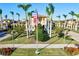 Attractive view of the community entrance with manicured lawn, mature trees, and an American flag at 12675 Richezza Dr, Venice, FL 34293