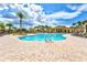 Community pool with palm trees, lounge chairs and spacious deck area at 12675 Richezza Dr, Venice, FL 34293