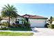 Beautiful single-story home featuring a barrel tile roof, tropical landscaping, and a two-car garage at 12675 Richezza Dr, Venice, FL 34293