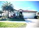 Charming single-story home with a well-manicured lawn, tropical landscaping, and a two-car garage at 12675 Richezza Dr, Venice, FL 34293