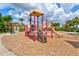 Community playground with slides and climbing equipment with mature trees nearby at 12675 Richezza Dr, Venice, FL 34293