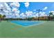 Community tennis court with green and blue surface and canopy covered bench at 12675 Richezza Dr, Venice, FL 34293