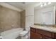 Well-lit bathroom features a shower over tub, granite vanity and tiled walls at 16904 Vardon Ter # 102, Bradenton, FL 34211