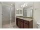 Bathroom featuring a granite countertop vanity, a glass-enclosed walk-in shower, and tiled flooring at 16904 Vardon Ter # 102, Bradenton, FL 34211