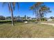 Backyard with a grassy area, trees, a canal, boat docks, and a tiki hut at 1956 Greenlawn Dr, Englewood, FL 34223