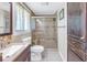 Updated bathroom featuring a tile shower, newer vanity, and wood cabinets at 1956 Greenlawn Dr, Englewood, FL 34223