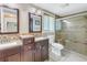 This bathroom has dual sinks, dark wood cabinets, and a glass enclosed shower at 1956 Greenlawn Dr, Englewood, FL 34223