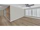 Open-concept living room displaying wood floors, an accent wall, and natural light through bright windows at 1956 Greenlawn Dr, Englewood, FL 34223