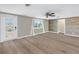 Bright living room featuring modern flooring, a ceiling fan, and a decorative accent wall at 1956 Greenlawn Dr, Englewood, FL 34223