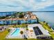 Aerial view of condo complex featuring pool, solar panels, and waterfront views at 2 Causeway Blvd # 206, Dunedin, FL 34698