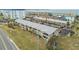 An aerial view of a charming multi-unit residential building with ample parking near the waterfront at 2 Causeway Blvd # 206, Dunedin, FL 34698