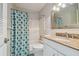 Bright bathroom featuring a shower, a toilet, and a vanity with ample lighting and storage at 2 Causeway Blvd # 206, Dunedin, FL 34698