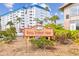 A clear view of the community signage with surrounding landscaping and building views showcasing the location at 2 Causeway Blvd # 206, Dunedin, FL 34698