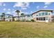 View of a condo building with large windows, a spacious lawn, and well-maintained landscaping at 2 Causeway Blvd # 206, Dunedin, FL 34698