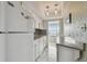 Bright kitchen featuring white appliances, marble floors, and light countertops at 2 Causeway Blvd # 206, Dunedin, FL 34698