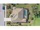 Overhead view of a home with a screen enclosed pool and spa combo, tile roof, and meticulous landscaping at 2023 Micanopy Trl, Nokomis, FL 34275