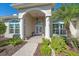 Inviting front entrance with stone walkway, arched entryway, white columns, and lush landscaping at 2023 Micanopy Trl, Nokomis, FL 34275