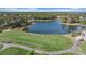 Aerial view of a golf course driving range and lake with beautiful views at 2023 Micanopy Trl, Nokomis, FL 34275