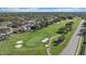 Aerial view of a golf course with sand traps, a golf cart, and manicured green at 2023 Micanopy Trl, Nokomis, FL 34275