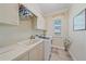 Functional laundry room with built in cabinets, counterspace, sink and modern washing machine at 2023 Micanopy Trl, Nokomis, FL 34275