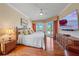 Inviting main bedroom featuring hardwood floors, TV, sitting area, and sliding glass doors to the backyard at 2023 Micanopy Trl, Nokomis, FL 34275