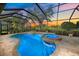 A beautiful covered pool with spa, views of a beautiful sunset and well maintained landscaping at 2023 Micanopy Trl, Nokomis, FL 34275