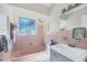 Retro bathroom with pink tile, a bathtub, and a gray vanity at 2040 Palm Ter, Sarasota, FL 34231