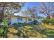 Light green house with a yellow door, surrounded by lush landscaping at 2040 Palm Ter, Sarasota, FL 34231