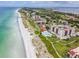 Gorgeous aerial view of a beach, luxury condos, and the ocean in the distance at 2089 Gulf Of Mexico Dr # G1-205, Longboat Key, FL 34228