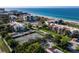 Aerial view of the community tennis courts, condos, beach and beautiful blue water at 2089 Gulf Of Mexico Dr # G1-205, Longboat Key, FL 34228