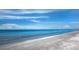 Expansive beach view with calm, clear, light blue waters and a cloud filled sky at 2089 Gulf Of Mexico Dr # G1-205, Longboat Key, FL 34228