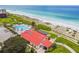 Stunning aerial shot of a red roof building, pool, and the ocean behind it at 2089 Gulf Of Mexico Dr # G1-205, Longboat Key, FL 34228