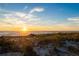 Serene sunset on a sandy beach with sea grass in the foreground at 2089 Gulf Of Mexico Dr # G1-205, Longboat Key, FL 34228