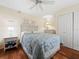 Comfortable bedroom featuring hardwood floors, a ceiling fan, and closet space at 2089 Gulf Of Mexico Dr # G1-205, Longboat Key, FL 34228