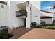 Inviting condo entrance with tiled floor, white bench, lush landscaping and unit number displayed at 2089 Gulf Of Mexico Dr # G1-205, Longboat Key, FL 34228