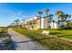 Inviting exterior of beachside condos with manicured lawn, palm trees, and an ocean view at 2089 Gulf Of Mexico Dr # G1-205, Longboat Key, FL 34228