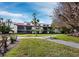 Picturesque condo exterior with manicured lawn, mature trees and partial water views at 2089 Gulf Of Mexico Dr # G1-205, Longboat Key, FL 34228