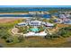 Aerial view of community clubhouse with pool, lush landscaping and ocean view at 272 Saint Lucia Dr # 101, Bradenton, FL 34209