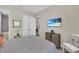 Inviting bedroom featuring a mounted TV and a glimpse into the en suite bathroom for added convenience at 272 Saint Lucia Dr # 101, Bradenton, FL 34209