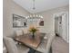 Dining room featuring modern chandelier, mirror, and six upholstered chairs at 272 Saint Lucia Dr # 101, Bradenton, FL 34209