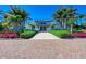 A clubhouse exterior is framed by palm trees, landscaped hedges, and a brick pathway leading to the entrance at 272 Saint Lucia Dr # 101, Bradenton, FL 34209