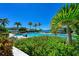 Serene outdoor pool area offering relaxing seating options surrounded by lush greenery and palm trees at 272 Saint Lucia Dr # 101, Bradenton, FL 34209