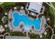 Aerial view of a large community pool featuring lounge seating, palm trees, and manicured landscaping at 3023 Vittorio Ct, Lakewood Ranch, FL 34211