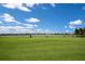 Scenic driving range view with palm trees and a serene lake, perfect for practicing your swing at 3023 Vittorio Ct, Lakewood Ranch, FL 34211