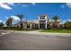 This exterior view showcases a modern building with manicured landscaping and lush palm trees at 3023 Vittorio Ct, Lakewood Ranch, FL 34211