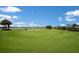 A sprawling golf course leads to a view of townhomes under a beautiful sky at 3023 Vittorio Ct, Lakewood Ranch, FL 34211