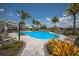 Large community swimming pool surrounded by lounge chairs and palm trees on a sunny day with blue skies at 3023 Vittorio Ct, Lakewood Ranch, FL 34211